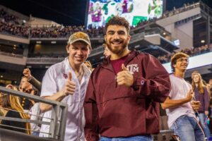 Paul and Franklin throwing a gig 'em (thumbs up) at a Texas A&M football game